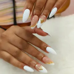 A clean and elegant look with crisp white nails and accent nails featuring a nude base with gold foil.