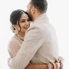 An intimate and joyful embrace between the bride and groom, showcasing a genuine moment of happiness and connection captured with a bright, airy feel.