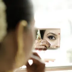 A creative shot capturing the reflection of her stunning eye makeup in a mirror. The precision of the liner and the delicate dots are key to this look.