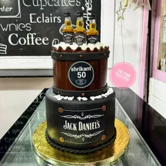 A two-tiered Jack Daniel's cake for a 50th birthday, featuring a barrel design and the iconic black label.
