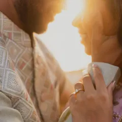 A close-up on the engagement ring as the couple shares an intimate moment. The focus on the hand and the ring tells a story of commitment against a backdrop of love.
