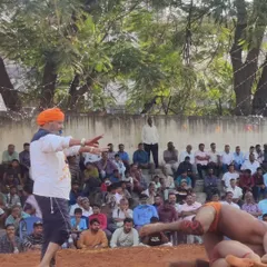 As a coach, I guide my wrestlers through every moment of the Dangal (wrestling competition). Here I am instructing a student on strategy from the edge of the akhada.