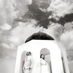 Using a low angle and a dramatic sky, this black and white shot creates a powerful, almost surreal portrait. The composition places the couple against the vastness of the clouds, giving the moment a grand, cinematic quality.