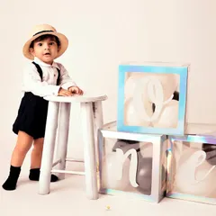 Making 'one' look so effortlessly stylish. This minimalist setup with a simple stool and balloon boxes keeps the focus on this dapper little boy and his classic outfit.