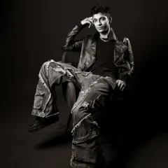 A relaxed, confident pose in a black and white studio setting that screams street style. The oversized jeans and leather jacket create a timeless, cool look.