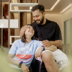 A sweet and loving look shared between the couple on their sofa, showing the comfort of being at home.