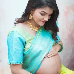 Celebrating tradition with a beautiful maternity portrait in a vibrant turquoise and lime green saree. This style of shoot, often called 'godh bharai' photography, honors cultural heritage while capturing the pregnancy glow.