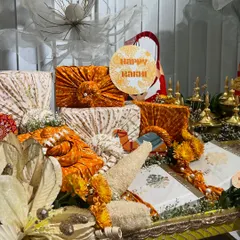 A closer look at the Rakhi trousseau, featuring gifts wrapped in beautiful orange and cream brocade fabrics.