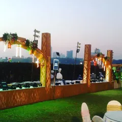 For this rooftop event, I designed a grand setup with a stunning city skyline view. The wooden archways and warm lighting created a sophisticated yet inviting ambiance for the evening.