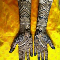 A gorgeous engagement mehendi featuring elegant peacocks at the top of the forearm. The design uses negative space to highlight the floral and geometric details, making it stand out beautifully.