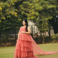A solo shot of the mom-to-be in our peach rental gown. The soft tulle and flattering silhouette are perfect for capturing the beauty of pregnancy.