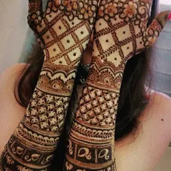 A rich, dense mehendi design featuring bands of lotus flowers and elephants. The palms are covered in intricate jaal work, creating a stunning look for any festive occasion.