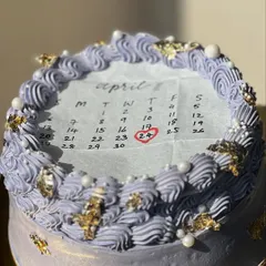 A lavender-colored burn away cake with gold leaf accents. The vintage piping and pearl details make it an elegant choice for a surprise celebration.
