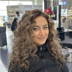 Another view of this elegant color on curly hair. The soft blends of color create a natural yet sophisticated look.