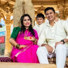 The complete family picture. This portrait captures the family of three, soon to be four, sharing a happy moment in a traditional setting.