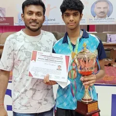 Celebrating a major win with one of our top players. He is holding his winner's certificate and trophy, a testament to his dedication and the effectiveness of our training methods.