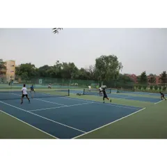 A wide view of multiple matches happening simultaneously across our courts. Our facility's capacity allows us to efficiently manage tournaments with a large number of participants and matches.