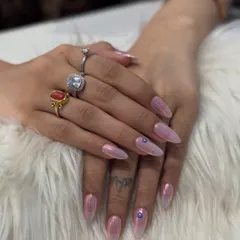 This is a beautiful example of a soft chrome look. I used a light pink iridescent chrome for a delicate, pearly shine on these long stiletto nails. I also added a tiny, hand-painted evil eye for a personal touch of protection.