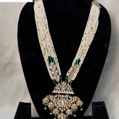 This is the long necklace from set B-06, which can be rented separately. It features strands of pearls and a heavy, antique-style pendant for a classic look.