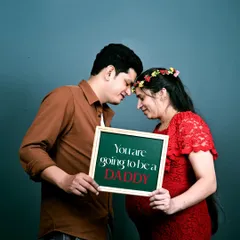 A fun and emotional moment during a studio maternity session. Using props like this slate adds a personal and playful touch to announce the great news. Let's tell your story together.