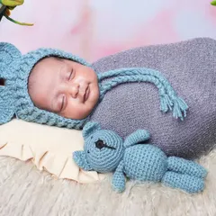 Capturing a precious sleepy smile on this newborn, dressed in a mouse-eared hat and resting in a comfortable prop basket.