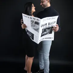 A full-length view of the couple reading their happy news. This newspaper prop, featuring their own ultrasound scan, is a fantastic and personal way to share your announcement.