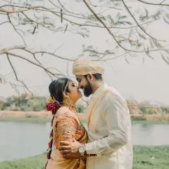 An almost-kiss under the gentle branches of a tree. This candid moment captures the sweet anticipation and romance of a traditional South Indian pre-wedding shoot.
