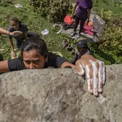 The focus and determination of a climber reaching the top of a boulder, with spotters ready below. This is from one of our outdoor events in Sethan.