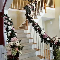 For home-based functions, I decorate interior spaces too. Here, I have wrapped the staircase railing in a thick, beautiful garland of artificial flowers in pastel shades to welcome guests inside.