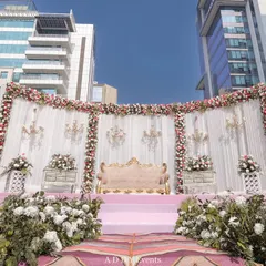 A wider angle of the outdoor floral stage, showing its impressive scale against the modern cityscape. This setup is perfect for daytime engagements or receptions, combining classic elegance with a contemporary urban setting.