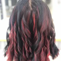 Adding highlights is a great way to create dimension. Here, I've woven striking red streaks through dark hair and finished with soft curls to really show off the contrast and movement in the style. This is a great option for a bold yet elegant change.