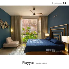 This bedroom in Rayyan features a deep blue accent wall and a geometric gold-finish headboard. The patterned jali window filters natural light, creating beautiful shadow play.