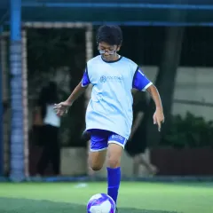 Mastering ball control is the first step to becoming a great player. This young footballer is captured practicing his dribbling, a foundational skill we emphasize in our grassroots football coaching program.