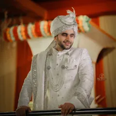 A classic portrait of groom Tayab Ahmad in his elegant white and silver sherwani. The soft lighting and confident pose make for a timeless groom photo.