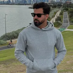 A close-up of our signature grey flared unisex tracksuit hoodie, highlighting its soft fabric and comfortable fit against a city skyline.