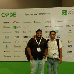 Building strong partnerships is key to success. I'm pictured here with a colleague at the CODE convention, in front of a wall of major sponsors like Google Cloud and Shopify, who are leaders in the digital space.
