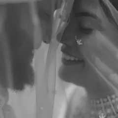 A soft and romantic black and white portrait of a couple under the bride's veil, creating a sense of intimacy and privacy.