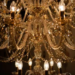 A detailed look at our magnificent multi-tiered crystal chandelier. Each arm is draped with shimmering crystal beads that reflect and refract light, creating an unparalleled sparkle. This fixture is a testament to classic European design and meticulous craftsmanship.