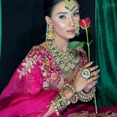 A romantic and classic pose with a single red rose. The model's makeup is bold and regal, fitting for this editorial concept.