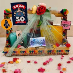 A Kathak-themed hamper for a music lover turning 50. This colorful gift includes a Kathak canvas painting, a themed journal, and other personalized items to celebrate her passions.