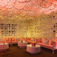 This is my signature Sheesh Mahal or 'Palace of Mirrors' concept. I use intricate mirror-work panels and soft, warm lighting to create an incredibly luxurious and dreamy lounge area. It’s a perfect, elegant space for guests to relax and socialize during a Sangeet or reception.