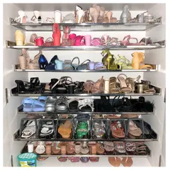This shoe closet is a colorful masterpiece. We organized this extensive collection by color and style, using a mix of open shelves and clear drop-front boxes for flats to maximize visibility.