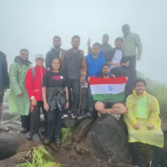 A proud moment for our trekking group on Independence Day, holding the flag high on a misty mountain peak.