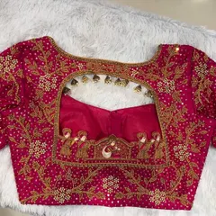 The back of the pink bridal blouse, featuring a stunningly detailed palanquin and peacock motif embroidered around the cutout.