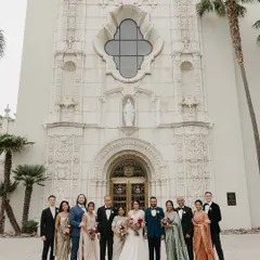 A beautiful family portrait outside the church. For this Catholic wedding, we styled the entire family in a coordinated palette of deep teal, white, sage green, and classic black, ensuring a cohesive and elegant look.