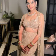 The full view of this elegant reception style. The soft makeup and chic updo allow the intricate details of her mermaid-style lehenga to shine.