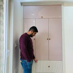 A custom wardrobe designed for a room in ATS Nobility. This piece features a beautiful combination of blush pink high-gloss laminate on the top and a textured white finish on the lower drawers.