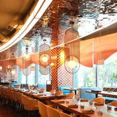 Welcome to our Mumbai dining room, a space designed for connection and celebration. The shimmering ceiling and warm lighting create an elegant yet comfortable setting, perfect for everything from a corporate dinner to a large family gathering.