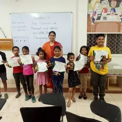 A moment of pride for our Vishakapatnam franchise. A teacher stands with her students as they display their trophies and certificates from the National Level Abacus and Vedic Maths Championship.
