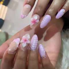 A close-up view of our detailed 3D sculpted nail art. Notice the intricate petals of the flower and the fine ridges of the seashell texture, all handcrafted by our skilled artists.